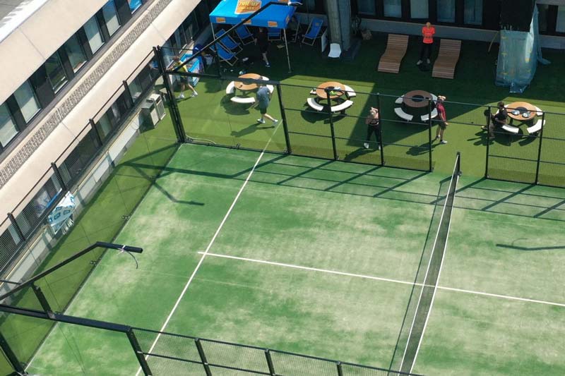 En padelbana med grönt konstgräs